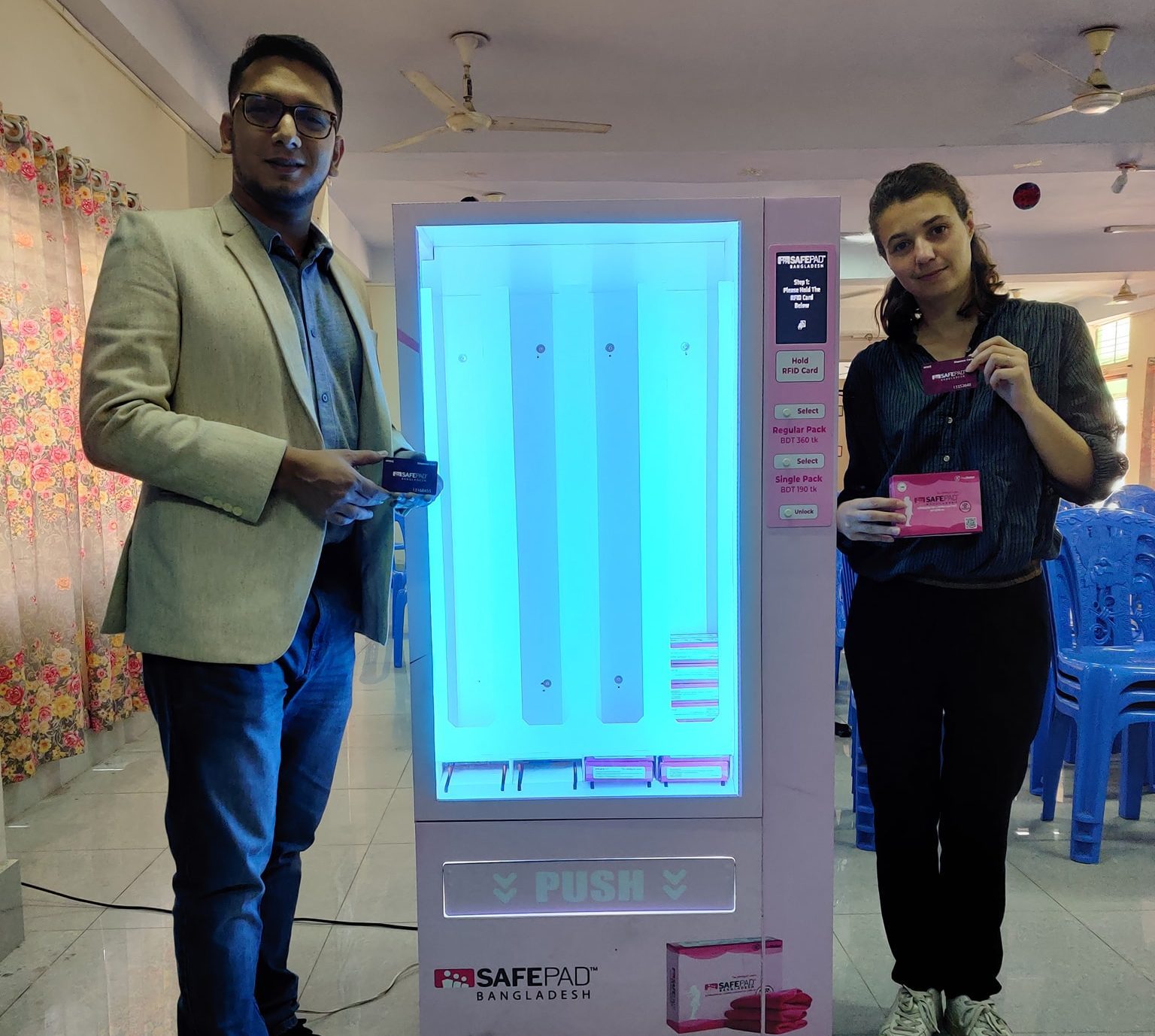 Safepad Bangladesh CEO Tahmid Kamal Chowdhury and Ms. Jeanne Charbit from HYSTRA based in Paris, France posing with Safepad Vending Machine, a specially customized version designed and developed by the Diva - Sanitary Pad Vending Machine team. A Proudly Made In Bangladesh product.